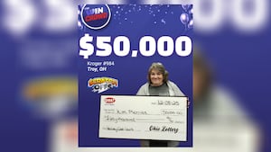 Женщина выбирает выигрышный лотерейный билет в местном продуктовом магазине